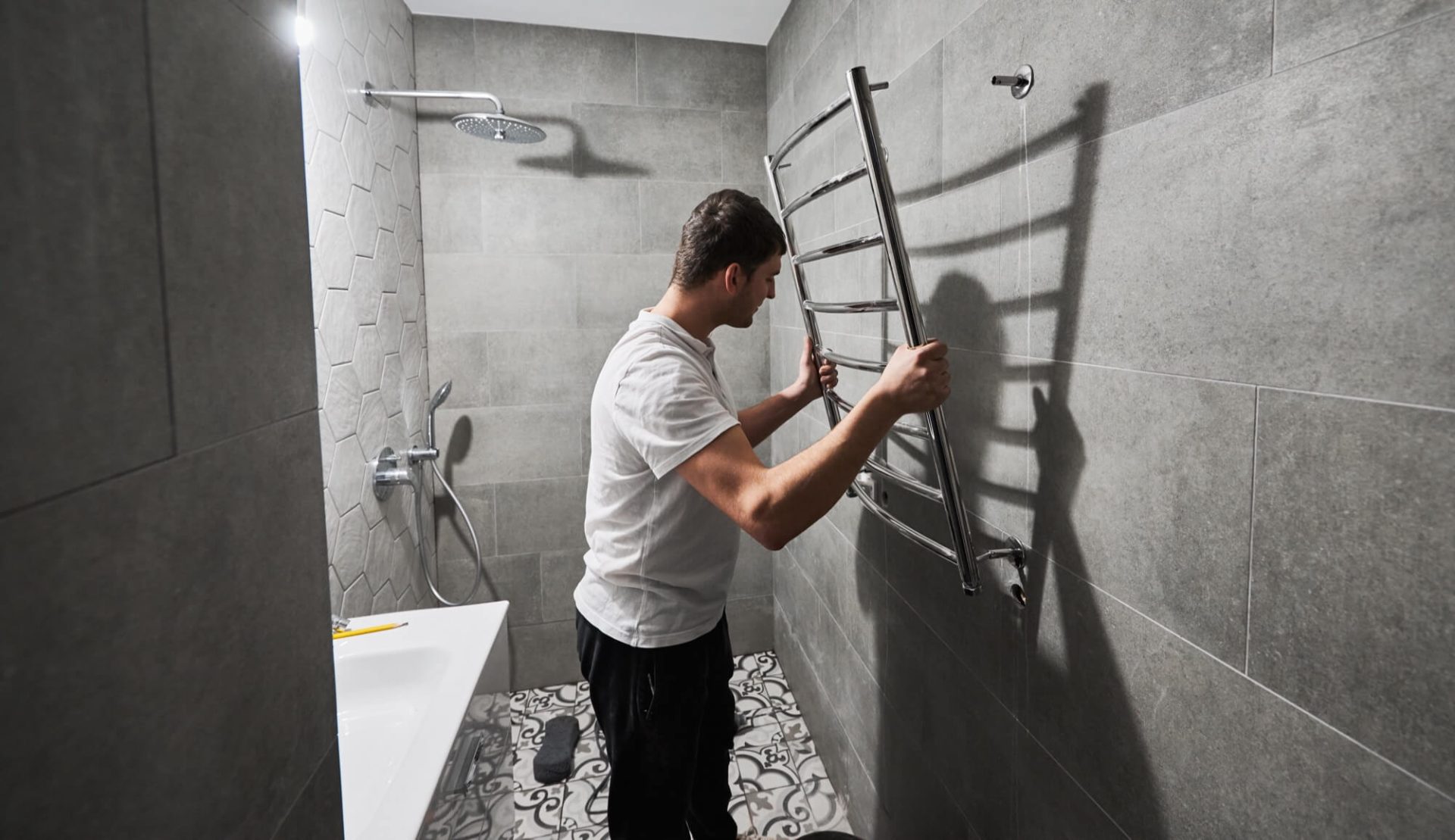 Väggmontering av handdukstork under badrumsrenovering.